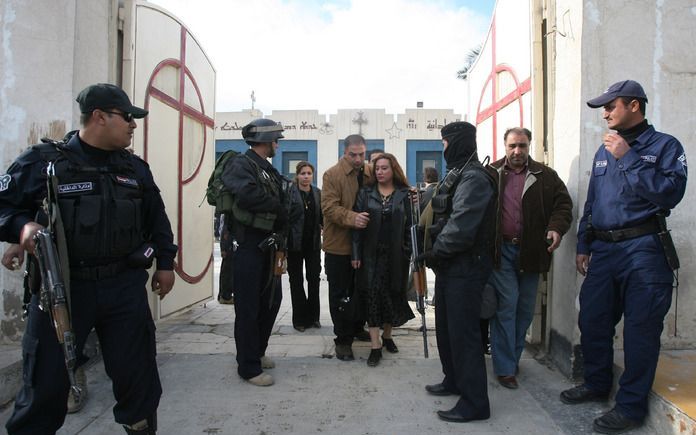 BAGDAD – Iraakse christenen passeren de beveiliging na een bezoek aan een kerkdienst. Deze week hadden meerdere aanvallen plaats op kerken en kloosters in Bagdad, Mosul en Kirkuk. Christenen zijn bang voor een „religieuze zuivering.” Foto AP