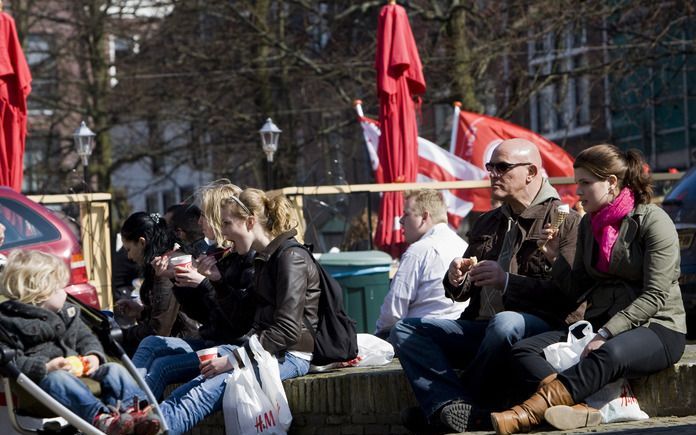 Mensen genieten van het mooie weer op de Gewelfde Stenenbrug in het centrum van Alkmaar. Foto ANP