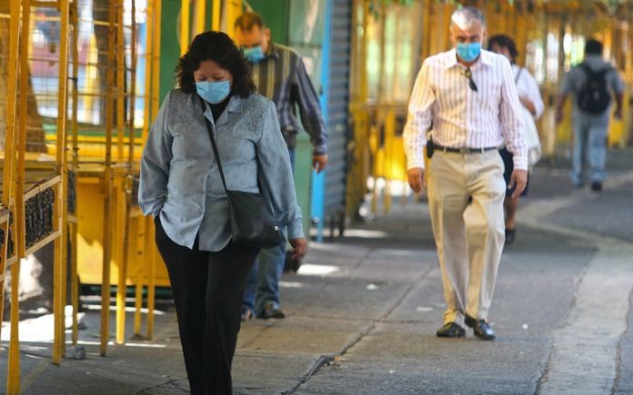 MEXICO-STAD – Een vrouw loopt met een beschermend mondkapje door de straten van Mexico-stad. De autoriteiten meldden donderdag dat testen hebben uitgewezen dat het griepvirus (type H1N1) sinds begin april aan zeker twaalf mensen het leven heeft gekost. Fo