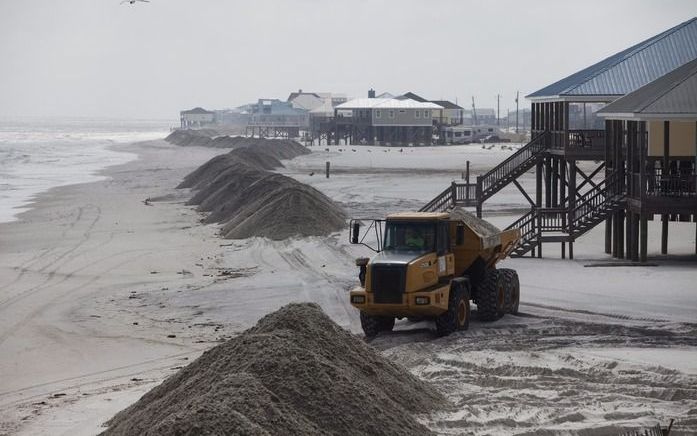 Werklieden werpen zandbarrières op tegen de olie langs de kust in Dauphin Island, Alabama. Foto EPA