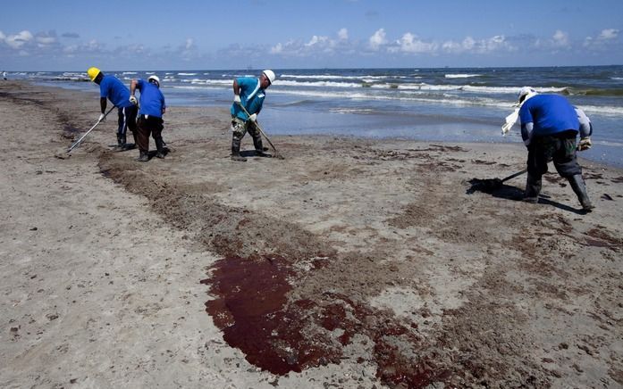 Mensen maken een met olie besmeerd strand langs de Amerikaanse kust schoon. Foto EPA