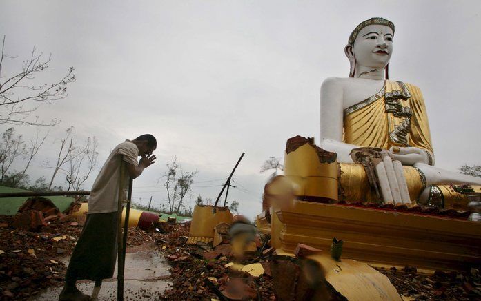 Een overlevende van de cycloon bidt bij een pagode, net buiten Rangoon. Foto's EPA