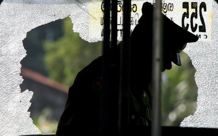 COLOMBO - Een agent bij de bus die vrijdag het doelwit was van terroristen. Foto EPA