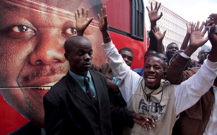 De bus van oppositieleider Morgan Tsvangirai wordt met gejuich begroet in de straten van Harare. Foto EPA