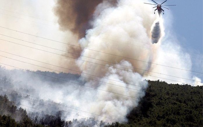 Een grote bosbrand aan de rand van Athene heeft de Griekse hoofdstad woensdag overdekt met rook en stroomuitval veroorzaakt. Foto EPA