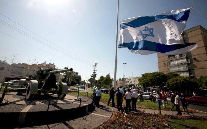 KIRYAT MOTZKIN - De Israëlische vlag hangt halfstok bij het appartement waar familie van de militair Eldad Regev. Foto EPA