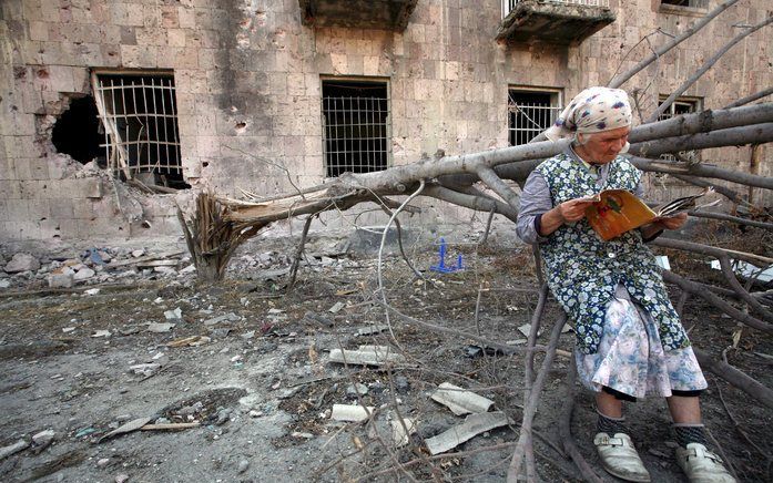 TBLISI - Een oudere vrouw voor haar verwoeste huis. De Europese Unie begint woensdag met haar waarnemersmissie in Georgië. Foto EPA