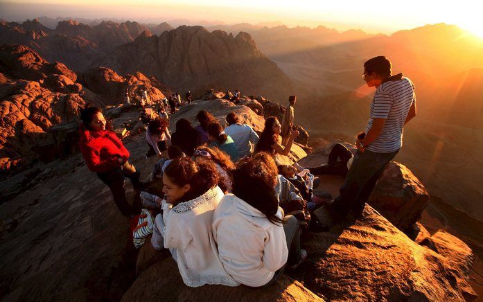 In Egypte neemt het geweld tussen bevolkingsgroepen toe. Op de foto geniet een groep christelijke scholieren op de Sinaï van de zonsopkomst. Foto EPA