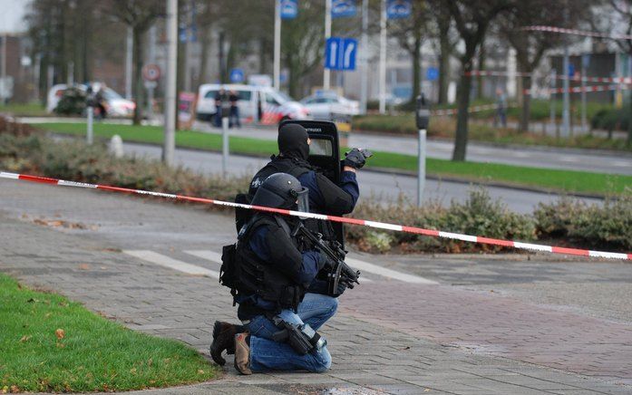 ZWIJNDRECHT - Twee leden van het arrestatieteam wachten bij het ABN Amro-kantoor in Zwijndrecht. Foto ANP