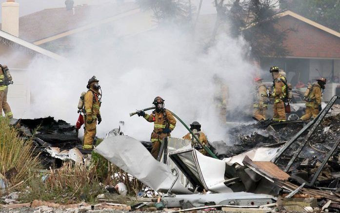 Hulpdiensten bij het wrak van de neergestorte straaljager van de Amerikaanse luchtmacht in San Diego. Foto's EPA