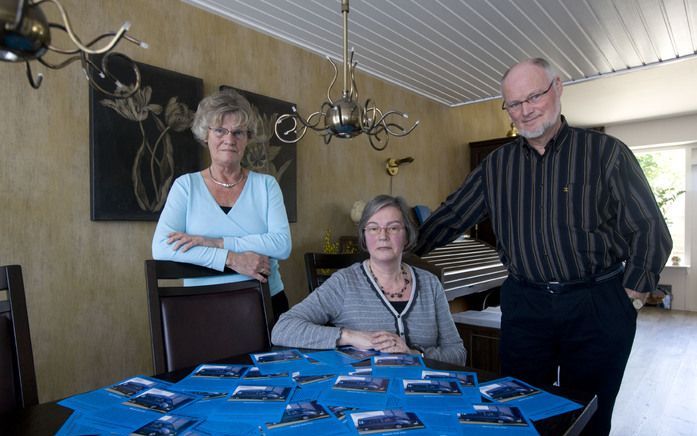 De actievoerders voor de rolstoelbus voor Nadine en Jurian achter een tafel vol flyers. V.l.n.r.: Lies de Berg, oma en opa Bron. Foto Herman Stöver