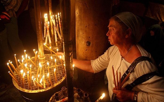 BETHLEHEM – Een pelgrim steekt een kaarsje aan in de Geboortekerk in Bethlehem. Paus Benedictus XVI bezoekt de kerk woensdag. Foto EPA