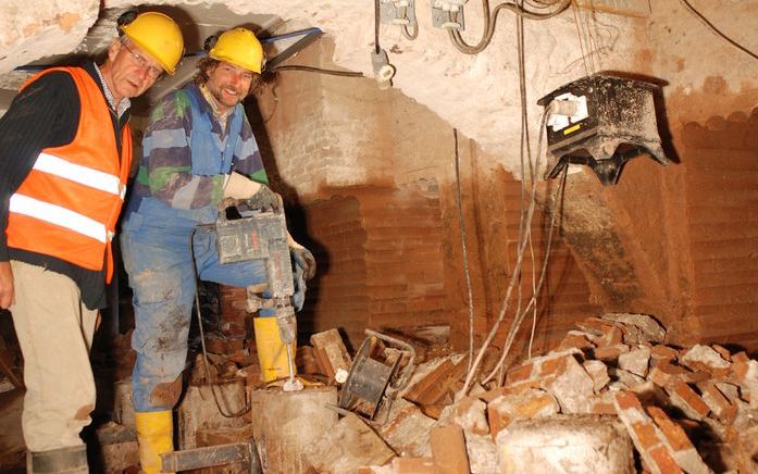 WILNIS – Aales van Leeuwen (l.) met een medewerker in de ontgraven kelder van de kerktoren van Wilnis. Om verzakking tegen te gaan, wordt het kerkelijk complex gerestaureerd. Het bedehuis is aangetast door de zogeheten palenpest. Foto RD