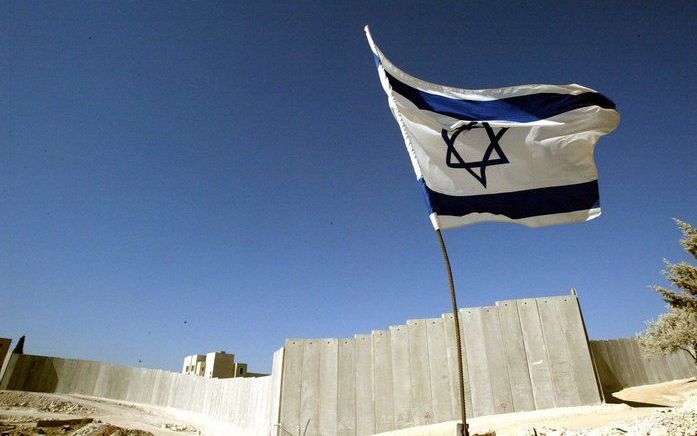 Een Israëlische vlag wappert bij de afscheidingsmuur op de Westbank. Foto EPA