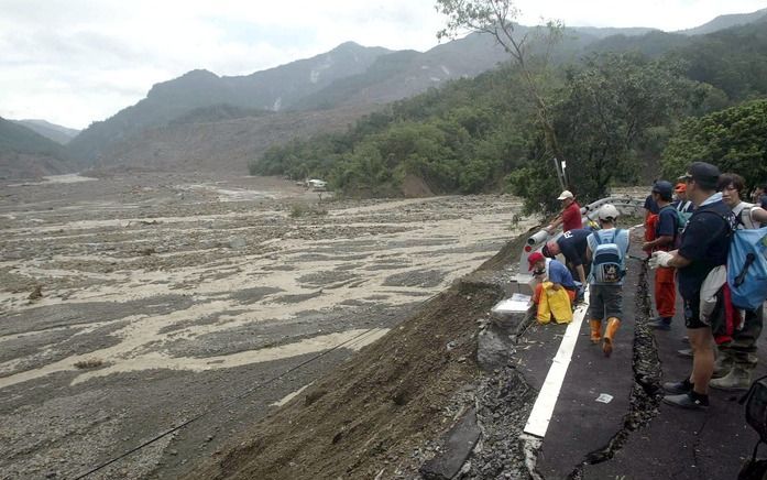 Reddingswerkers kijken naar de plaats waar een week geleden nog een dorp lag, zuid-Taiwan. Foto EPA