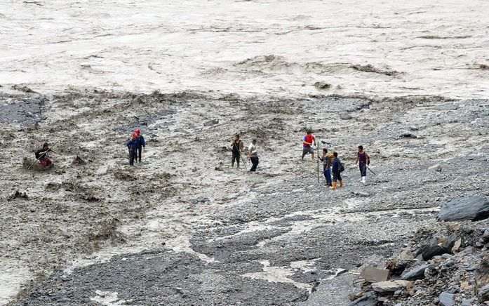 KAOHSIUNG – Reddingswerkers zochten woensdag op een moddervlakte in de provincie Kaohsiung, in het zuiden van Taiwan, naar slachtoffers van de tyfoon Morakot. Het aantal vermisten dat sinds maandag in Taiwan is gered, lag woensdag op duizend. Foto EPA