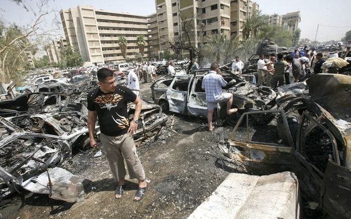 BAGDAD - Iraakse burgers staan woensdag bij het ministerie van Buitenlandse Zaken. Ministeries en andere regeringsgebouwen in Bagdad werden getroffen door een reeks autobomexplosies en mortierinslagen. Foto EPA