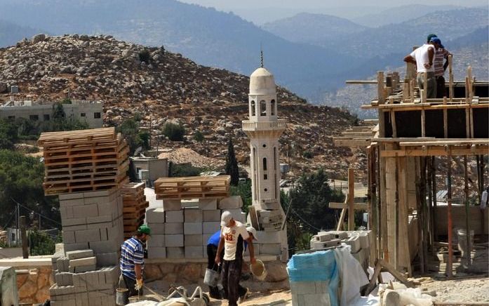 Palestijnse arbeiders bouwen aan de Joodse wijk Gilo, een van de omstreden nederzettingen. Foto EPA