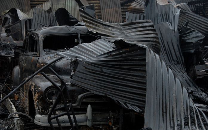 AMSTERDAM – Een verbrand historisch legervoertuig tussen de puinhopen van een aantal loodsen aan de Amsterdamse Havenstraat. Bij de brand zondag gingen vijftien historische legervoertuigen van Keep them Rolling in vlammen op. Foto Ronald Bakker