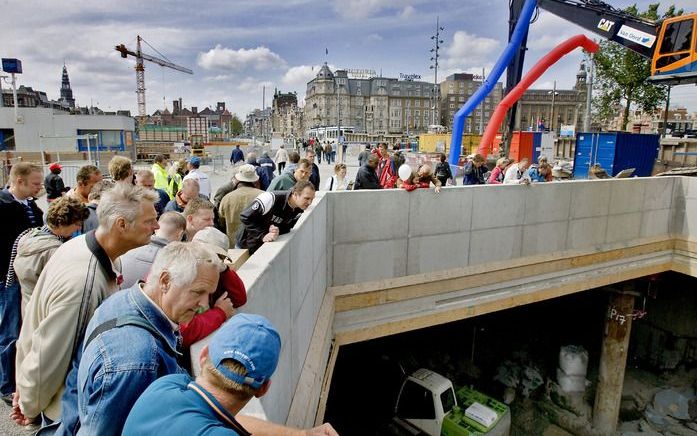 Nieuwsgierige voorbijganger bij een bouwlocatie van de N/Z-lijn. Foto ANP.