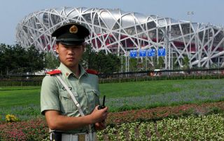 Een politieagent voor het olympisch stadion, beter bekend als het Volgelnest, in Peking. Foto EPA