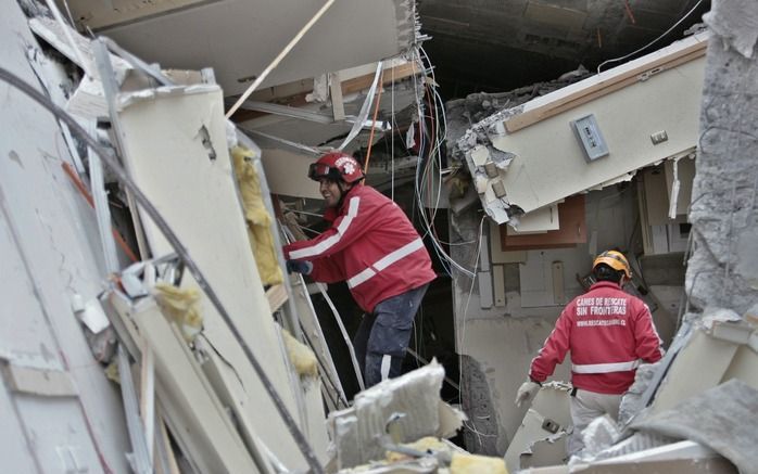 Reddingswerkers zoeken naar overlevenden in de verwoeste gebouwen. Foto EPA.