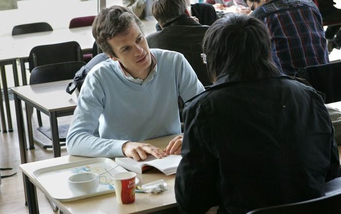 Arjen den Admirant in gesprek met een Chinese student op de campus in Utrecht. beeld RD, Anton Dommerholt