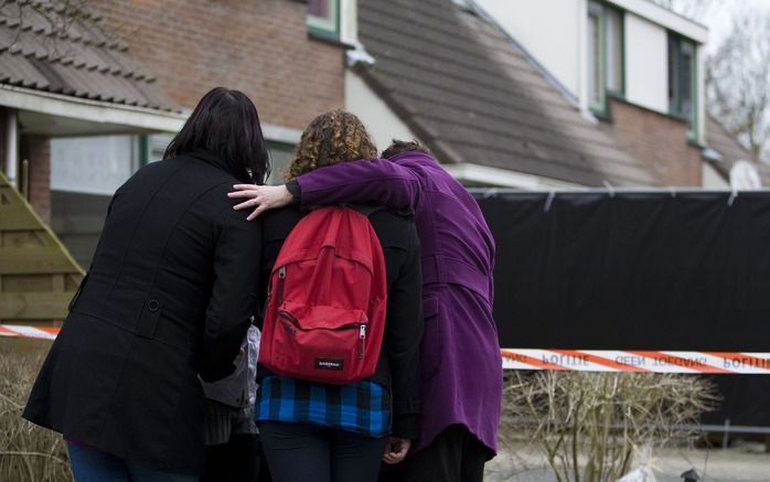 ZIERIKZEE - Scholieren zoeken maandag steun bij elkaar voor het huis in Zierikzee waar in de nacht van zaterdag op zondag bij een familiedrama drie gezinsleden om het leven kwamen. Foto ANP