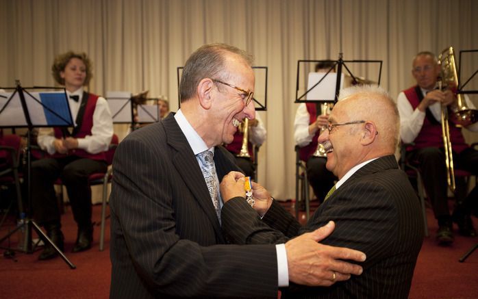 WOUDENBERG – Stuk voor stuk dragen ze hun steentje bij aan de samenleving. Duizenden Nederlanders zijn vandaag koninklijk onderscheiden. In Woudenberg kregen tien mensen een lintje. Burgemeester J. van Bergen (r.) speldde onder anderen M. Blokhuis de erev