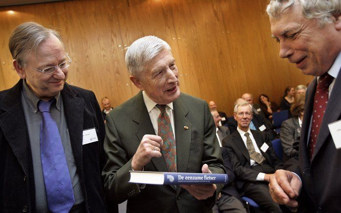 DEN HAAG – Oud-premier Van Agt (m.) ontving woensdag in Den Haag het eerste exemplaar van ”De eenzame fietser” van VU-onderzoeker dr. A. Koster (l.). Het boek beschrijft Van Agts politieke loopbaan. Prof. mr. C. Fasseur (r.) overhandigde het boek gisteren