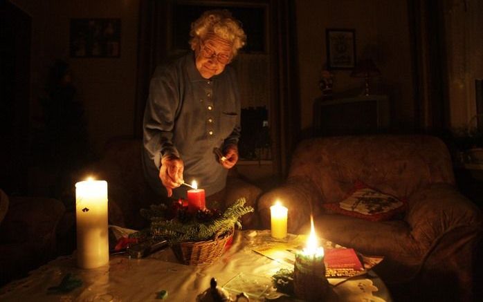 ZALTBOMMEL - Weduwe Timmermans (93) steekt kaarsjes aan in haar woonkamer omdat Zaltbommel zonder stroom zit. Foto ANP