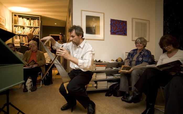 Dirk Luijmes en Arnold Marinissen willen met het project ”Huiskamermuziek” de afstand tussen musicus en hoorder verkleinen. Foto: Marinissen met een zaag tussen zijn benen die hij met een strijkstok bespeelt. Foto's Gerrit Jan Huinink