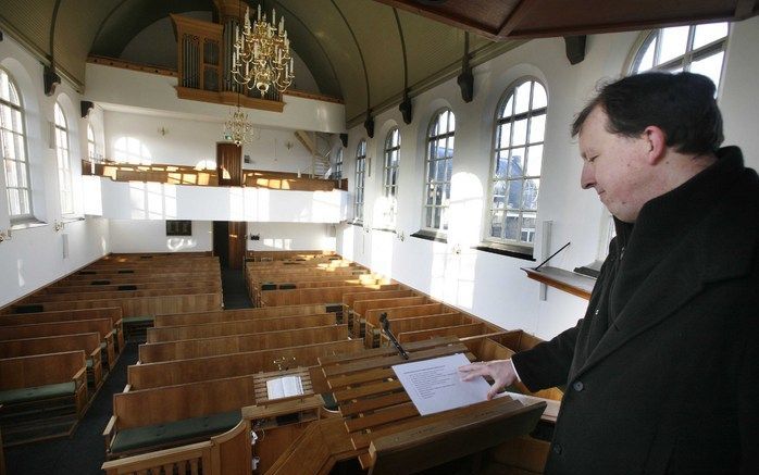 ZUILICHEM – Ds. J. A. C. Olie bij de lege lessenaar op de kansel van de kerk in Zuilichem, waar een Statenbijbel is gestolen. „Als ze de Bijbel zouden meenemen om daarin te lezen, zouden ze echt rijk zijn. Maar als ze hem stelen voor het geld, zijn ze ech