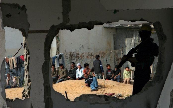 GAZA - Een Palestijnse militair houdt de wacht tijdens een luchtaanval van Israël boven vluchtelingenkamp Jabaliya. Foto EPA