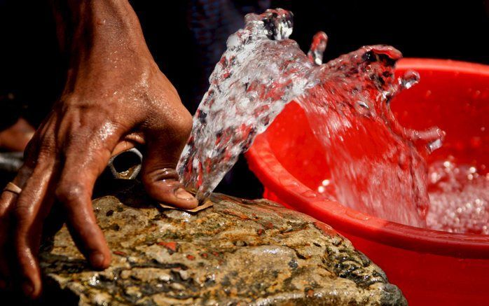 BANGLADESH - Een Bengaalse man haalt water bij een publieke kraan langs de weg. Acute armoede, overbevolking, miserabele huisvesting en slechte beschikking over water zijn aan de orde van de dag in de stedelijke gebieden van Bangladesh. Foto EPA