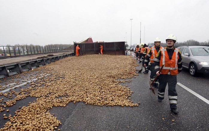 VELDHOVEN - Een gekantelde vrachtwagen heeft zaterdag op de A2 bij Veldhoven een kilometerslange file veroorzaakt. Een deel van de lading, 30 ton aardappelen, is op het wegdek terechtgekomen. Foto ANP