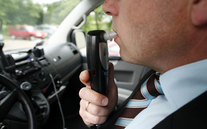 ”Test ok”, verschijnt op het schermpje van het alcoholslot. De man die blies, kijkt tevreden. Hij heeft niet gedronken en kan zijn auto vanwege het resultaat starten. Foto ANP.