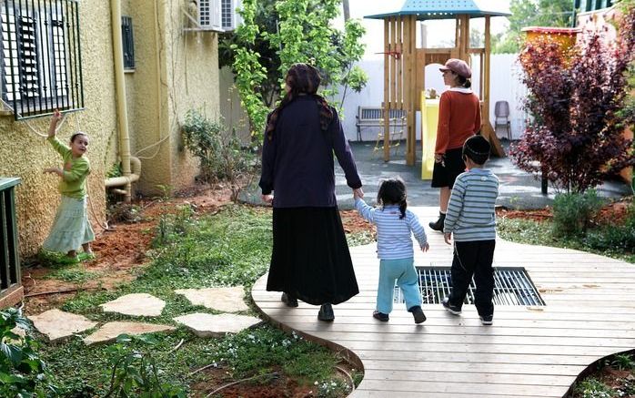 Sara (m.) met twee van haar kinderen op de binnenplaats van Miklat Bat Melech. Het opvangcentrum herbergt momenteel negen vrouwen en achttien kinderen uit orthodox joodse kring. Foto Sjaak Verboom