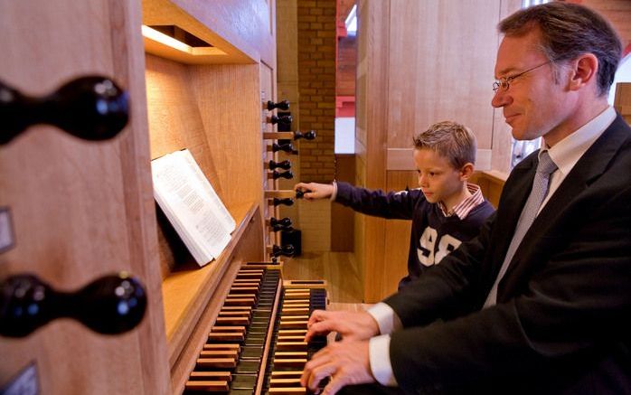 DORDRECHT – Organist en kerkenraadslid Dick van Luttikhuizen met zijn zoon Coert bij de speeltafel van het orgel van de gereformeerde gemeente in Dordrecht. „Ik heb zondags altijd heel bewust een van de kinderen meegenomen naar het orgel. Laat ze maar naa