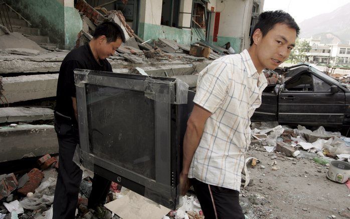 Overlevenden van de aardbeving in China zoeken hun bezittingen bij elkaar. Foto EPA