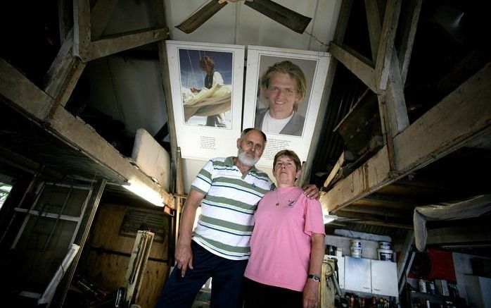 Het echtpaar Toxopeus op de brug in de garage waar Evert oldtimers repareert en restaureert. Op de achtergrond twee foto’s van hun vermiste zoon Jan Jaap. Foto’s Sjaak Verboom