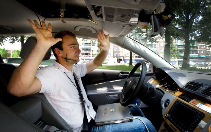 EINDHOVEN – Er zit een bestuurder achter het stuur maar hij doet niets; de auto rijdt vanzelf. Vrijdag werden in Eindhoven proeven gedaan met slimme auto’s. Foto’s ANP