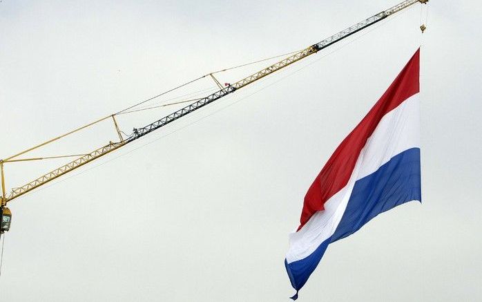 SCHEVENINGEN - Een Nederlandse vlag van 18 bij 27 meter hangt zaterdag tijdens Vlaggetjes 2008 boven de haven van Scheveningen. Zeer waarschijnlijk gaat het om de grootste vlag die ooit in Nederland is opgehangen. Het doek is bevestigd aan een hijskraan. 