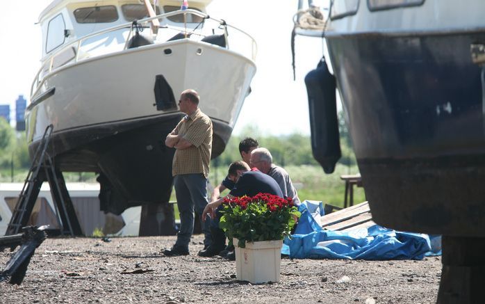 DE PUNT - Verslagenheid bij collega-brandweerlieden die een grote bak met rozen hebben neergezet voor de brandweerlieden die zijn omgekomen bij de brand op de jachtwerf van Beuving in De Punt. Archieffoto ANP