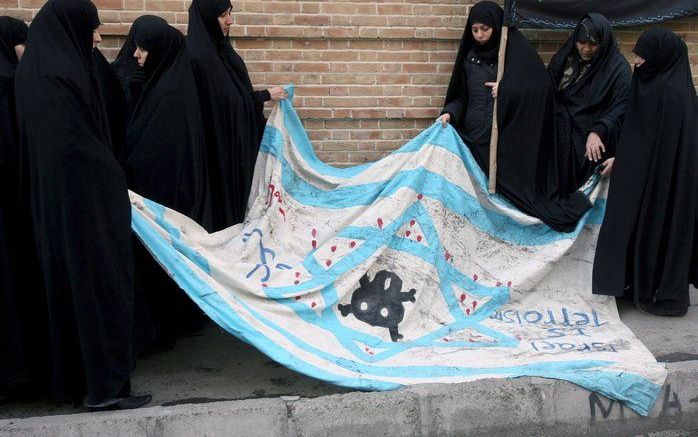 TEHERAN - Iraanse vrouwen dragen een anti-Israelvlag tijdens een protest tegen de Israelische aanvallen op de Gazastrook, januari 2008.