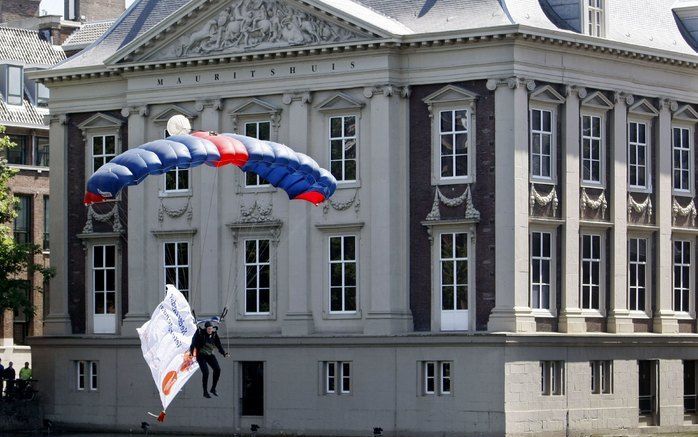 DEN HAAG - Een van de vier parachutisten landt vrijdag in de Hofvijver in Den Haag op een klein ponton. Met de actie wordt aandacht gevraagd voor de landelijke veteranendag die op zaterdag in Den Haag wordt gehouden. Het betreft drie springers van het Kor