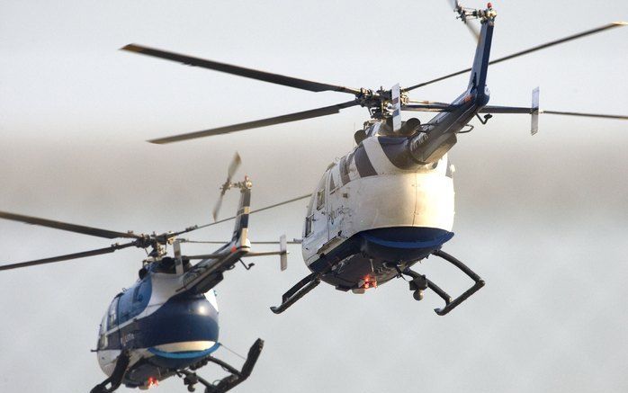 De Bosnisch-Servische oud-president Radovan Karadzic vertrekt woensdagmorgen met een politiehelikopter (rechts) met begeleiding (links) van Rotterdam Airport.