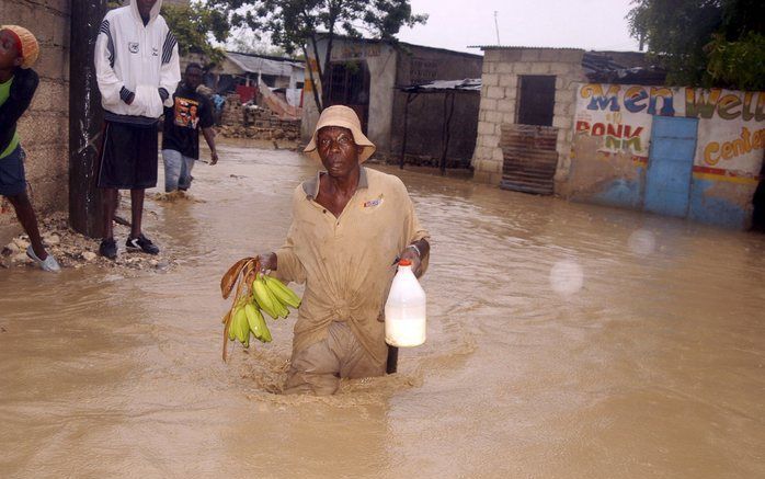 PORT AU PRINCE – Een man baant zich een weg door een ondergelopen straat in Cité Soleil, een krottenwijk bij de Haïtiaanse hoofdstad Port au Prince. Haïti en de Dominicaanse Republiek werden de afgelopen dagen getroffen door de orkaan Gustav. Foto EPA