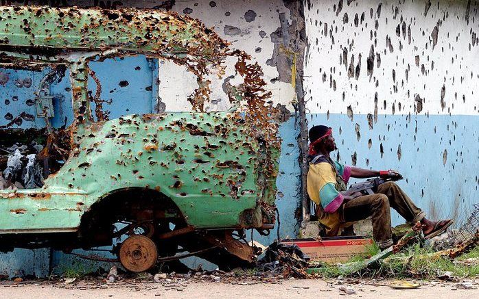 Liberia was na vijftien jaar oorlog en conflict in 2003 grotendeels in puin geschoten. Deze rebel bewaakt de oprit van een brug in de hoofdstad Monrovia. Veel rebellen en soldaten verlieten na afloop van de strijd het leger en kwamen zonder opleiding op s