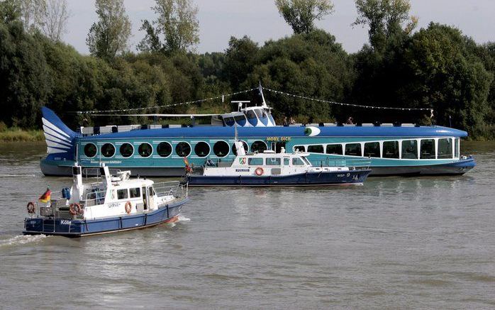 Nationalisten in Keulen zoeken vrijdag hun toevlucht op een schip op de Rijn, dat vervolgens door demonstranten wordt bekogeld. Foto EPA.